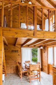 - une salle à manger en bois avec une table et des chaises dans l'établissement BOG Ocrehue - Cabanas, à Villa La Angostura