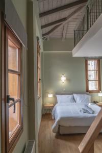 ein Schlafzimmer mit einem weißen Bett und einem Fenster in der Unterkunft Anastasia's Suites Arcadia in Vitina