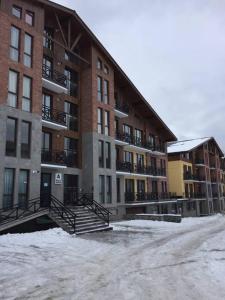 a building with snow on the ground in front of it at Park residence in Bakuriani