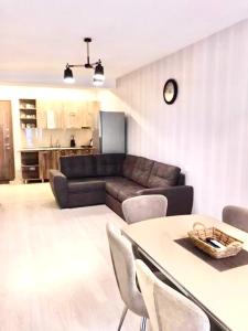 Una sala de estar con un sofá y una mesa con sillas. en Park residence, en Bakuriani
