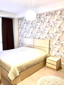 Un dormitorio con una cama y una pared con triángulos. en Park residence, en Bakuriani