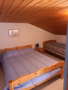 - une chambre avec un lit et un plafond en bois dans l'établissement Talaris La Palmyre, aux Mathes