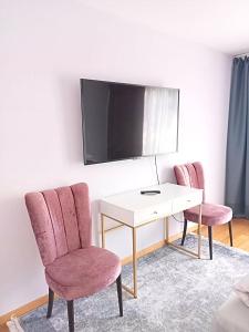 um quarto com duas cadeiras, uma secretária e uma televisão em Alpen Panorama view Luxury House with green Garden em Buchs