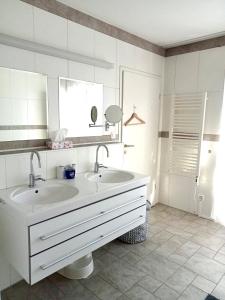 a white bathroom with a sink and a mirror at Alpen Panorama view Luxury House with green Garden in Buchs