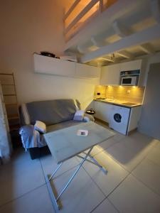 a small kitchen with a couch and a table in a room at Les hauts d'azur in Saint Pierre La Mer