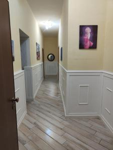um corredor com paredes brancas e pisos de madeira em Oikos em Boscotrecase