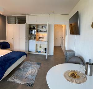 a bedroom with a bed and a table and a kitchen at Seeblick Bissone in Bissone