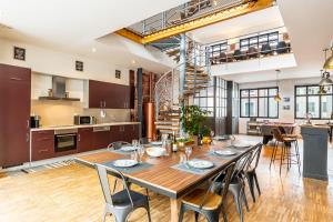 an open kitchen and dining room with a wooden table and chairs at Le 48-GregIMMO-Appart'Hôtel in Montbéliard