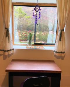 a window with curtains and a wooden bench in front of it at Sonqo Andino Hospedaje Medicina - La Rinconada in Pisac +20 photos