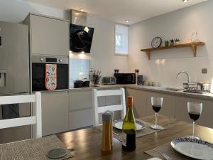 a kitchen with a table and two glasses of wine at Coachmans Cottage in Aberlour