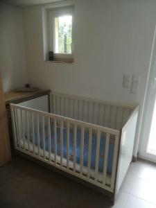 a white crib in a room with a window at Ehemaliges Torhaus am Rande der Dresdner Neustadt in Dresden