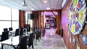 una sala da pranzo con tavoli, sedie e un muro di hotel brahimi batna a Batna