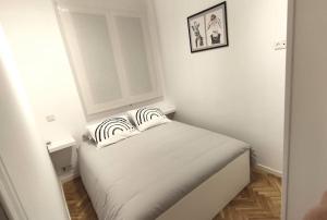 una piccola camera da letto con un letto con due cuscini sopra di Lovely apartment in Madrid center (Chueca) a Madrid