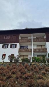 a building on a hill with bushes in front of it at Ferienwohnung im Allgäu mit Bergsicht in Oberreute +5 photos