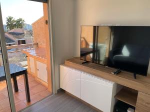 - un salon avec une grande télévision à écran plat dans l'établissement Appt T2 refait à neuf - vue mer dans résidence avec piscine, à Mandelieu-la-Napoule