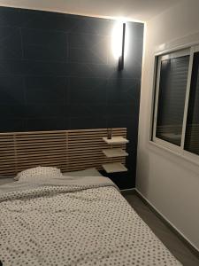 sypialnia z łóżkiem i czarną ścianą w obiekcie Appt T2 refait à neuf - vue mer dans résidence avec piscine w mieście Mandelieu-la-Napoule
