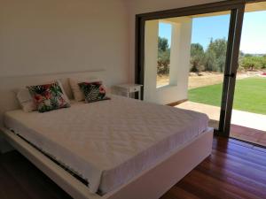 a bedroom with a large bed with a large window at Casa do Cabeçudo in Faro