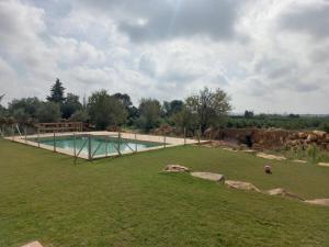 a large grassy field with a swimming pool at Casa do Cabeçudo in Faro