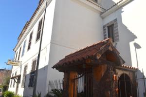 un bâtiment blanc avec un toit marron dans une rue dans l'établissement Albergo Ollolai, à Civitavecchia