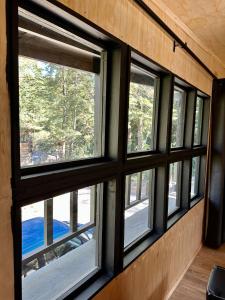 a group of windows in a room with trees at Molco Cabins Palafito in Pucón