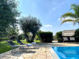 eine Terrasse mit 2 Stühlen und einem Pool in der Unterkunft Villa Rita - Puglia Mia Apartments in Antonelli