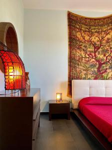 Schlafzimmer mit einem roten Bett und Wandteppich in der Unterkunft Villa Rita - Puglia Mia Apartments in Antonelli