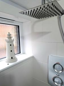 a lighthouse sitting in a window in a bathroom at Old Tavern House in Fortrose