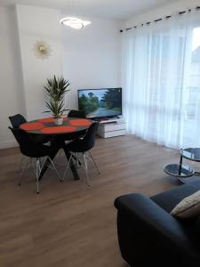 salon ze stołem, krzesłami i telewizorem w obiekcie Bel appartement centre Rouen avec terrasse w Rouen