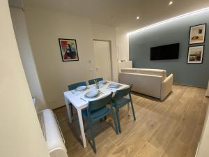 a living room with a table and chairs and a couch at Colombo 1935 - Apartments in Follonica +8 photos