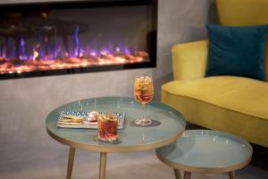 泰拉諾瓦布拉喬利尼的住宿－Moody smart & comfy Hotel，壁炉旁的桌子上放着一杯葡萄酒