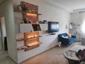 a living room with a couch and a tv on a wall at Dar Rimayssa in Temara