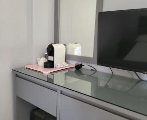 einen TV auf einem Glastisch in der Unterkunft Vila Chelsea in Ksamil