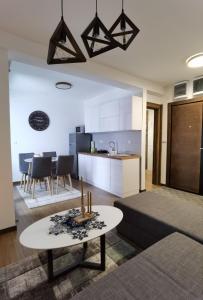 uma sala de estar com uma mesa e uma cozinha em Borovi 2 Divcibare/apartman 7 em Divčibare