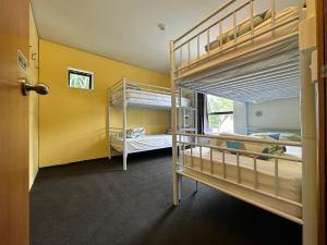 Habitación con 2 literas y puerta. en Around The World Backpackers en Christchurch