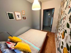 ein Zimmer mit einem Bett mit gelben Kissen darauf in der Unterkunft Artic Home Apartman-nearby city center! in Pécs