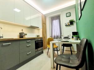 a kitchen with a table and chairs in a room at Artic Home Apartman-nearby city center! in Pécs
