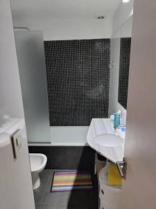 a bathroom with a sink and a toilet and a mirror at Departamento Loft Pichincha in Rosario