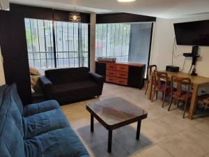 sala de estar con sofá y mesa en Departamento Loft Pichincha en Rosario