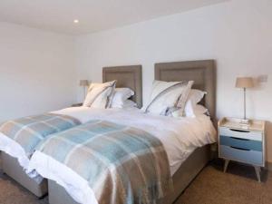 a bedroom with a large bed and a night stand at Franks, Cowes - Sleeps 4 - 2 Bed - 2 Bath - Central Location in Cowes