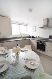 a kitchen with a table with plates and flowers on it at Franks - Cowes in Cowes