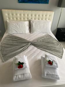 a bed with two towels and two roses on it at SEA FRONT in Armação de Pêra
