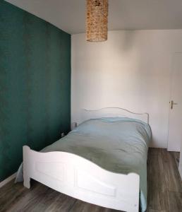 a white bed in a room with a green wall at APPARTEMENT AVEC TERRASSE SUR LE PORT in Fécamp