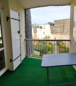 a balcony with a table and a view of a building at APPARTEMENT AVEC TERRASSE SUR LE PORT in Fécamp