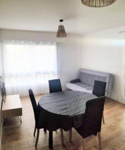 a dining room with a table and chairs and a couch at APPARTEMENT AVEC TERRASSE SUR LE PORT in Fécamp