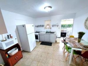 a kitchen with a white refrigerator and a table with chairs at Casa Doña Guilla 2 
