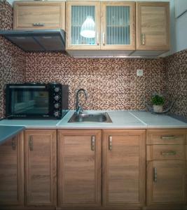 a kitchen with a sink and a microwave at Angie's House Volos in Volos