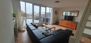 a living room with a couch and a table at Appartement Uniekappart in Uitgeest