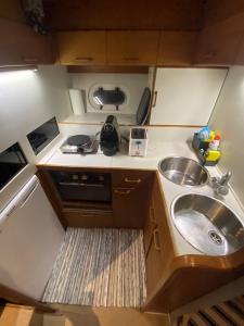 a small kitchen with a sink and a microwave at Barco Princess Cachucho Fly in Puerto Calero
