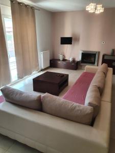 uma sala de estar com um sofá grande e uma televisão em Marianna's House em Ýpsos