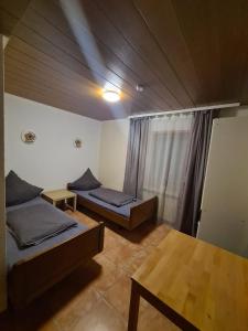 Zimmer mit 2 Betten und einem Tisch in der Unterkunft Ferienhaus Auszeit in Seebach